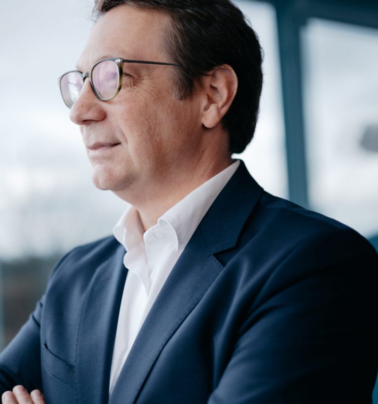 Mag. Bernd Trappmaier von der Seite, der aus dem Fenster schaut